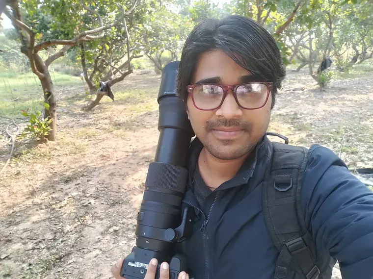 Kishan Tiwari in the field with a tripod.